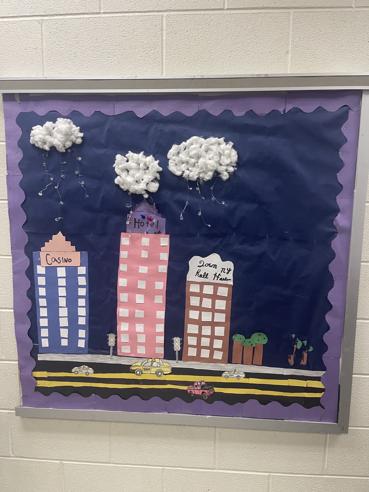 Student-created city night storyboard with a casino, hotel, taxis, and rain clouds
